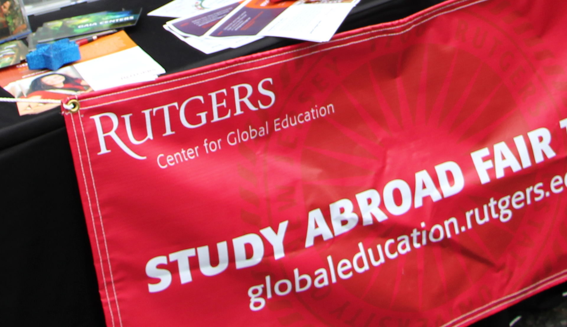 Rutgers Global - Spring 2016 Study Abroad Fair, study abroad fair today banner on exhibit table with assortment of Rutgers Global flyers