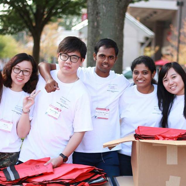 Rutgers Global – International Student and Scholar Services, five students in white tee shirts smile for a photo on College Avenue, outdoors