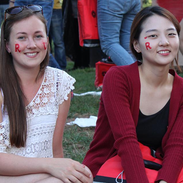 Rutgers Global – IFP, two students enjoy an outdoor picnic with "R" spirit mark face paint on their faces