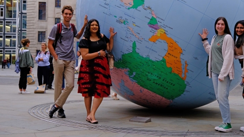 students standing in front of a big globe