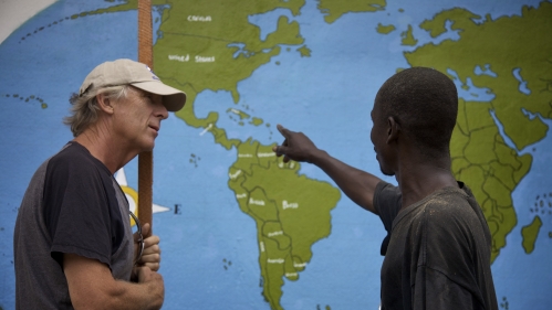 a man wearing a hat on the left and a man pointing at maps on the right