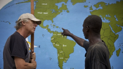 a man wearing a hat on the left and a man pointing at maps on the right