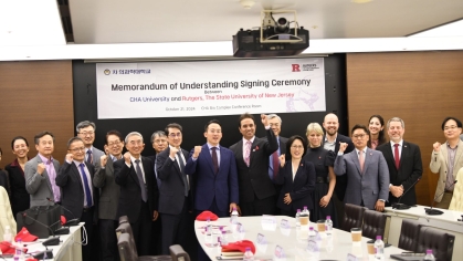 This image captures a group of dignitaries and representatives from CHA University and Rutgers University during the Memorandum of Understanding (MoU) signing ceremony on October 21, 2024. The setting, marked by a banner behind the group, highlights a formal yet celebratory atmosphere, with individuals raising their fists in a gesture of collaboration and achievement. This event symbolizes a significant partnership aimed at advancing academic and institutional cooperation.