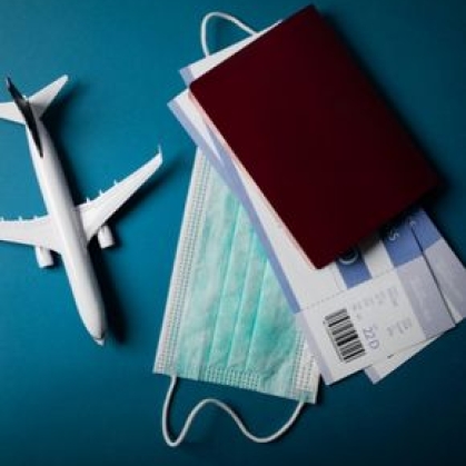 Stock photo of toy airplane, mask, plane tickets