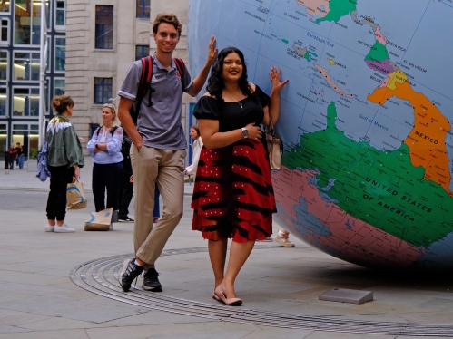 students standing in front of a big globe