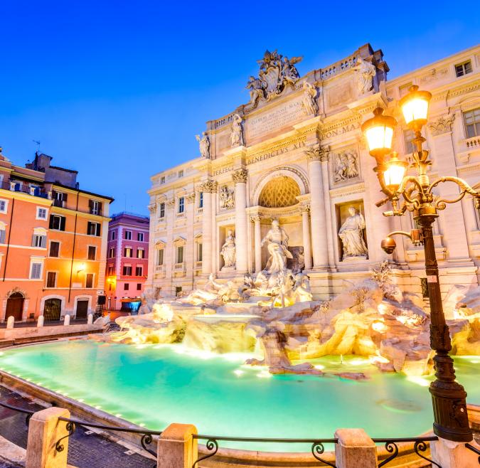 The Trevi Fountain is illuminated at dusk