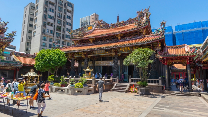 People walking in front of the gate of Longshan Temple in Taipei, Taiwan