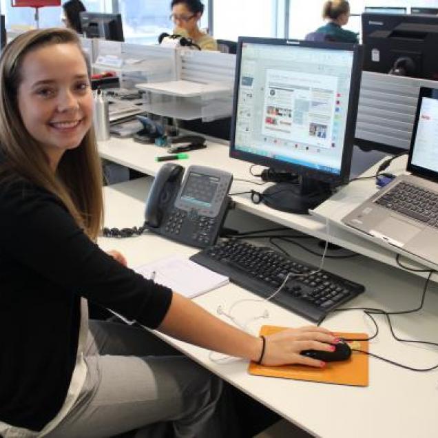 GAV Student Intern smiling at computer