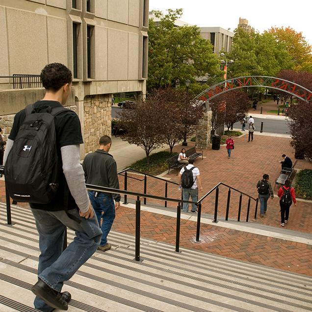 Rutgers Global – International Exchange Students, students wearing backpacks descend steps at Rutgers–Newark campus 