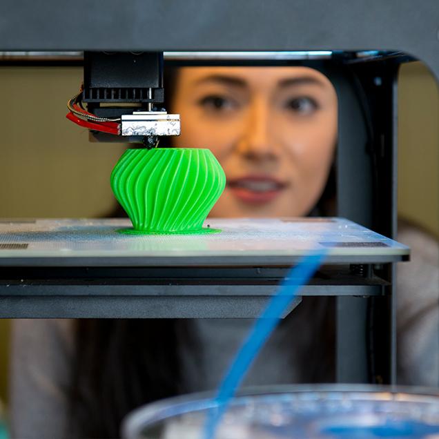 Rutgers Global – Summer Session and Hybrid Language Program, student watches 3-D printer produce a green votive